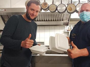 Der Disponent Thomas Auer (rechts) ist auch selbst unterwegs. Hier holt er im Restaurant Kainz "Essen auf Rädern" ab.