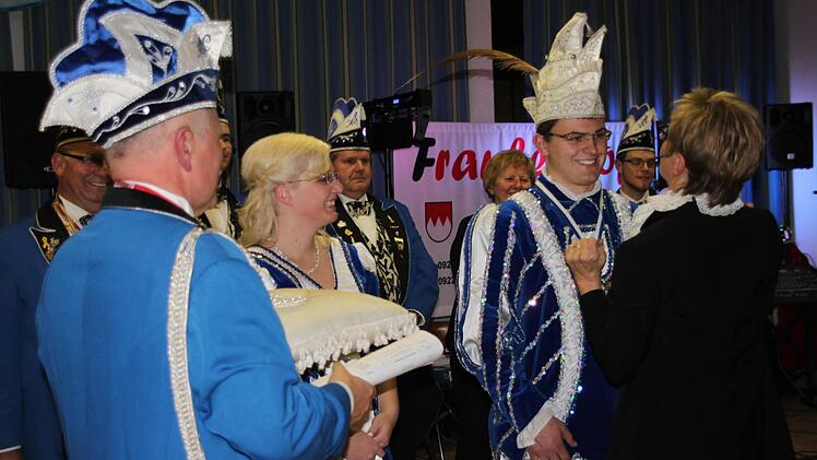 Sitzungspräsidentin Christine Friedlein (rechts) hat dem neuen Prinzen, Philipp I. die Narrenkappe aufgesetzt. Darüber freut sich Prinzessin Andrea I.