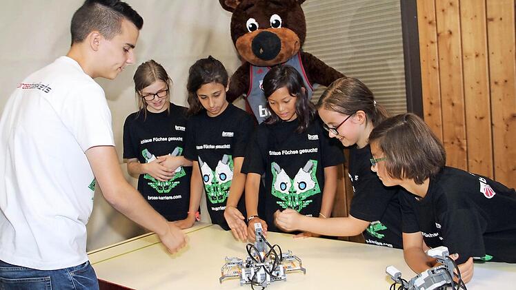 Brose-Auszubildender Marco Zeulner (links) zeigt, wozu Sensoren zu gebrauchen sind. Maskottchen Freaky schaut zu. Fotos: Gerda Völk