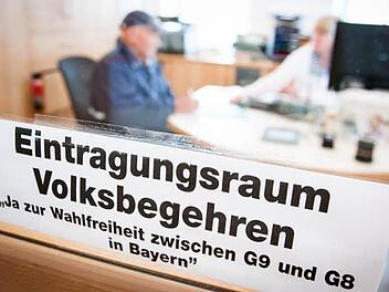 Hugo Baum (links) gibt im Regionalen Informations- und Tourismuszentrum (Ritz) in Eltmann seine Unterschrift für das Volksbegehren der Freien Wähler ab. Deutliche Beschilderung weist den Eltmanner Bürgern den Weg zum Eintragungsraum.  Fotos: Hendrik Steffens