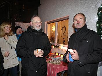 Otto Müller (rechts) und seine Frau Ingrid Hartmann (links) mit Gästen an ihrem Adventsfenster. In der Mitte Rudolf Wagner-Jakob, der 1995 zu den Initiatoren gehörte. Alle Fotos: Barbara Herbst