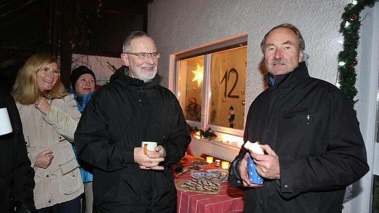 Otto Müller (rechts) und seine Frau Ingrid Hartmann (links) mit Gästen an ihrem Adventsfenster. In der Mitte Rudolf Wagner-Jakob, der 1995 zu den Initiatoren gehörte. Alle Fotos: Barbara Herbst