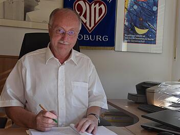 Hubert Joppich an seinem Arbeitsplatz in der Awo-Geschäftsstelle vor einer historischen Fahne. Er steht seit 25 Jahren ehrenamtlich an der Spitze des Awo-Kreisverbandes. Foto: Gabi Arnold