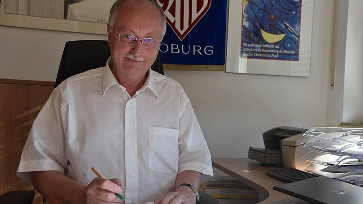 Hubert Joppich an seinem Arbeitsplatz in der Awo-Geschäftsstelle vor einer historischen Fahne. Er steht seit 25 Jahren ehrenamtlich an der Spitze des Awo-Kreisverbandes. Foto: Gabi Arnold