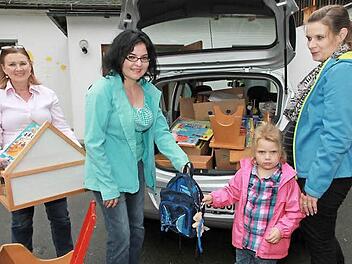 Spende für Flüchtlinge: Susanne Wicht (2.v.l.) und Kindergartenleiterin Juliane Schneider (links) beladen das Auto mit Spielsachen aus dem Kindergarten Willersdorf. Die kleine Emily hilft mit, sie packt einen kleinen Kinderrucksack mit Teddybär ins Auto.  Foto: Mathias Erlwein