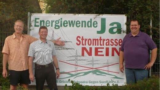 In Schondra, am Ortseingang an der Kissinger Straße, steht eines der Banner, das (von links) BI-Vorsitzender Reiner Morshäuser (Singenrain), stellvertretender Vorsitzender Jochen Knüttel (Schildeck) und Bürgermeister Bernold Martin präsentieren. Foto: Oswald Türbl