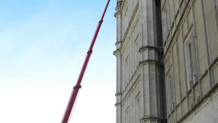 Vom Sockel bis zum liliengeschmückten Sims fährt der Hubsteiger die Fassade ab.