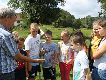 Harro Preiss zeigt den Kindern aus Heiligenstadt seinen Meteoriten, den sein Vater vor vielen Jahren gefunden hatte. Foto: Carmen Schwind