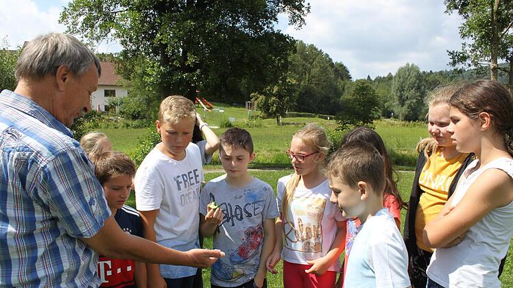 Harro Preiss zeigt den Kindern aus Heiligenstadt seinen Meteoriten, den sein Vater vor vielen Jahren gefunden hatte. Foto: Carmen Schwind