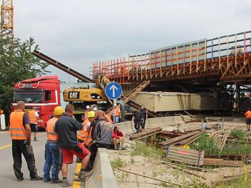 Ein roter Tieflader blieb mit seinem geladenen Bagger am Dienstagmittag in einer Autobahnbrücke in Forchheim hängen. Foto: Ronald Heck