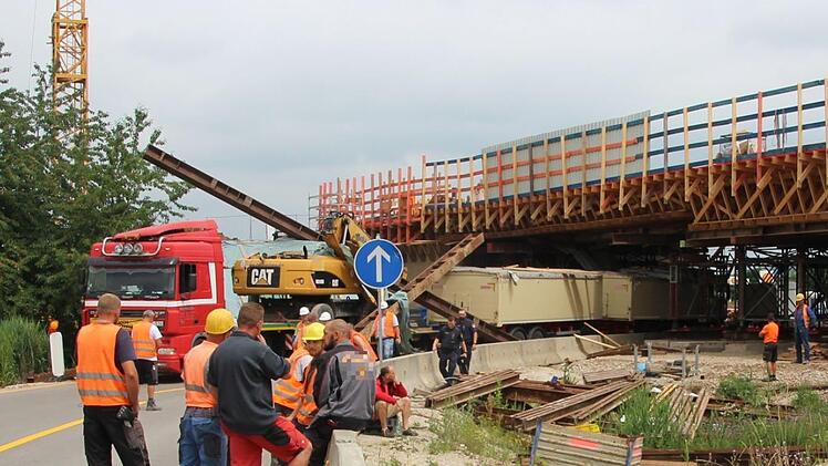 Ein roter Tieflader blieb mit seinem geladenen Bagger am Dienstagmittag in einer Autobahnbrücke in Forchheim hängen. Foto: Ronald Heck