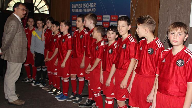 "Anzugskontrolle"; FRG-Schulleiter Klauspeter Schmidt bestaunt die neuen Trikots der Schulauswahl.