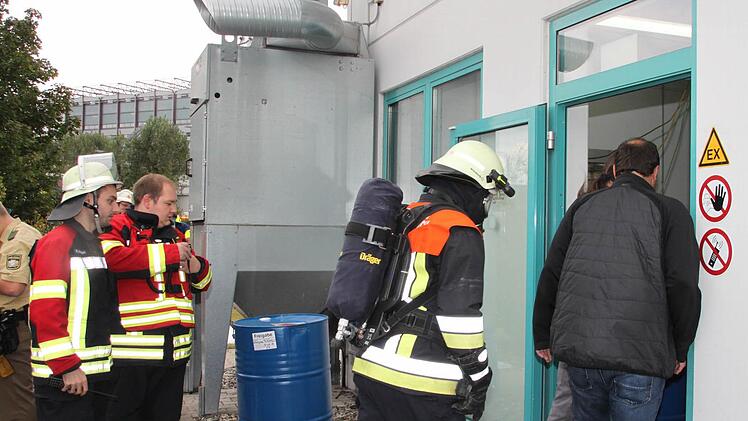 Gefahr gebannt: Feuerwehrleute und Mitarbeiter der Firma CoMI besichtigen die Produktionshalle, in der es gebrannt hat. Foto: Stephan Tiroch
