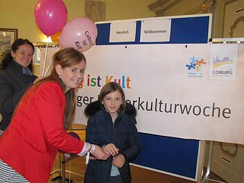 Bianca Haischberger befestigt ein Freundschaftsband am Arm von Franziska R. Mit auf dem Bild ist Stephanie R., Franziskas Mutter. Foto: Martin Koch