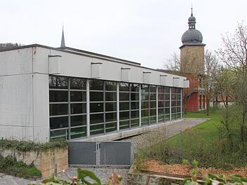 Das Hallenbad der Stadt Zeil liegt am Schulberg. Dahinter sind die Mittelschule (rote Fassade) und der Stadtturm ("Hexenturm").  Klaus Schmitt