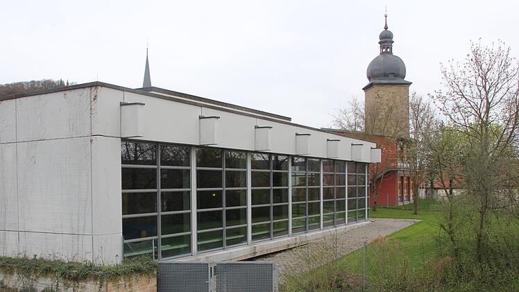 Das Hallenbad der Stadt Zeil liegt am Schulberg. Dahinter sind die Mittelschule (rote Fassade) und der Stadtturm ("Hexenturm").  Klaus Schmitt