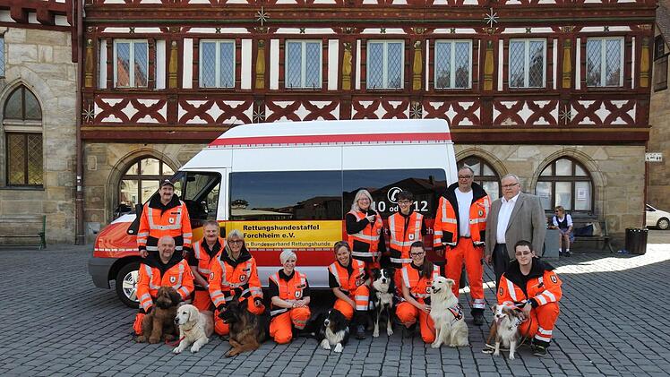 Bürgermeister Franz Streit (rechts) mit der Rettungshundestaffel und dem neuen Fahrzeug.  Foto. Petra Malbrich