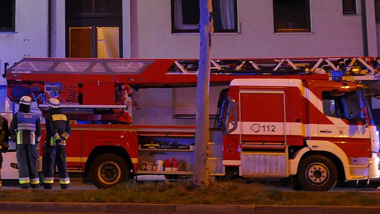 Feuerwehreinsatz mit Drehleiter in der Nacht an einem Wohnhaus