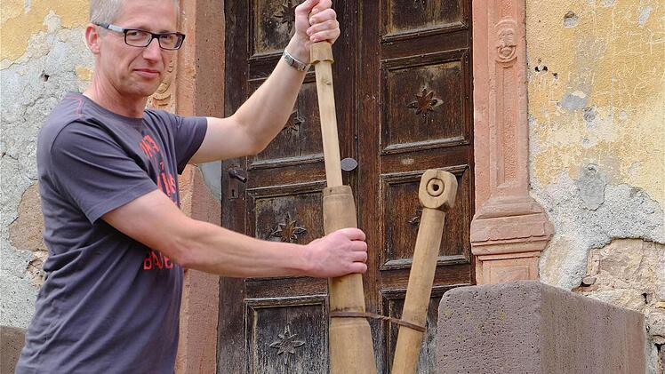 Kommandant Ivo Straube zeigt die hölzerne Krückenspritze aus dem 17. Jahrhundert. Foto: Schaar