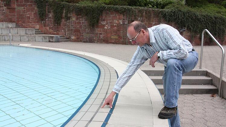 Roland Bühner zeigt schadhafte Stellen im Nichtschwimmerbereich.