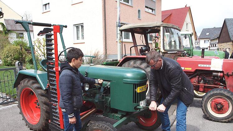 Jürgen Panzer kurbelt hier unter Mithilfe seines Sohnes seinen Hatz-Bulldog vom Baujahr 1957 an.