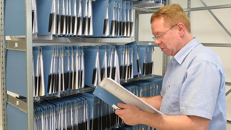 Joachim Burger zieht einen weiteren Asylantrag aus dem Aktenschrank. Foto: Ronald Rinklef