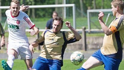 Gegen die H&ouml;fleser Stefan Reif-Beck und Jan Haas (gelbe Trikots von links) versucht sich der Wei&szlig;enbrunner Andreas Ge&szlig;lein mit einem Distanzschuss. Foto: Heinrich Wei&szlig;