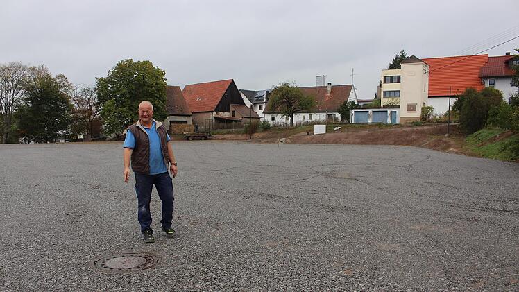 Im nächsten Jahr soll sich der jetzt noch graue Festplatz in frischem Grün zeigen. Zweiter Bürgermeister JosefWichert zeigt, woin diesem Jahr der Kirchweihbaumstehen wird.