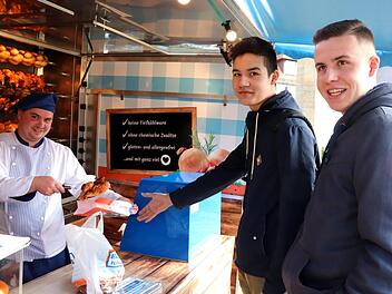 Das Hähnchenauto am Marktplatz in Adelsdorf: Eugen Nicolae Birlonca grillt für Gabriel und Alexander Münch (von links).  Foto: Johanna Blum