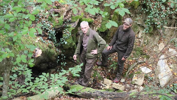 Hans Stark (links), der Leiter des Universitätsforstamts Sailershausen, und sein Kollege Björn Lieblein haben in dieser Schlucht unterhalb des Diebsbrunnens im Sailershäuser Wald einen Geocache in einer Baumwurzel gefunden. Eine Stelle, die nach Meinung der beiden Forstleute nicht für Geocaching geeignet ist, da das Gebiet unter Naturschutz steht.  Foto: Friederike Stark