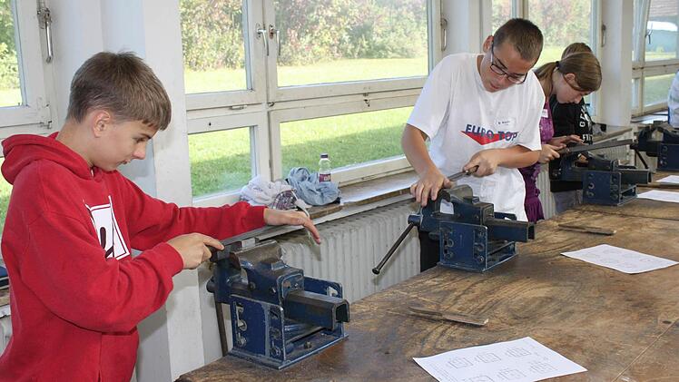 Philipp und Kevin (von links) zeigen beim Feilen ihr Geschick. Foto: may