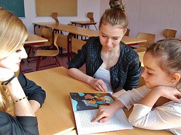 Die Lesepaten Madeleine Beer (links) und Larissa Kiesewetter (beide 16) vom Jack-Steinberger-Gymnasium mit Sinnberg-Drittklässlerin Maxima Diehl (8). Foto: Sigismund von Dobschütz