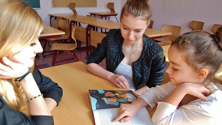 Die Lesepaten Madeleine Beer (links) und Larissa Kiesewetter (beide 16) vom Jack-Steinberger-Gymnasium mit Sinnberg-Drittklässlerin Maxima Diehl (8). Foto: Sigismund von Dobschütz