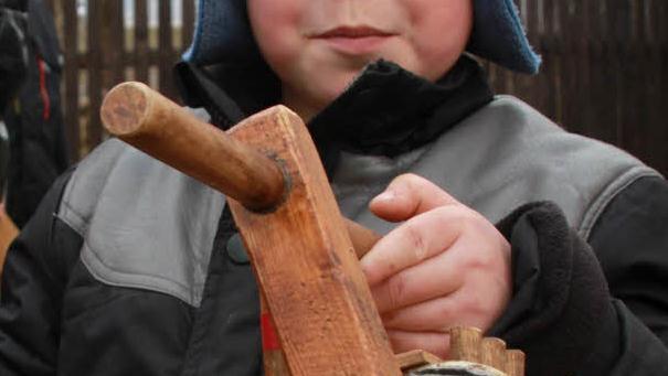 Lukas ist stolz auf die Holzratsche, die er von seinem Opa bekam.