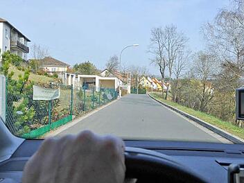 Die Kellerstraße nach der Sanierung: Auch die Bewohner des  Neubaugebiets (im Hintergrund) nutzen sie jetzt  zur Anfahrt - rechts das umstrittene unbebaute Grundstück.   Foto: Ronald Rinklef