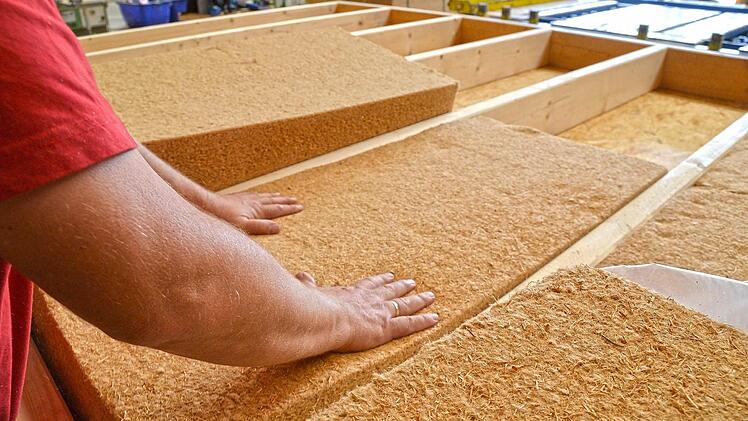 Holzteile für den Modulbau werden mit einer Dämmung versehen.