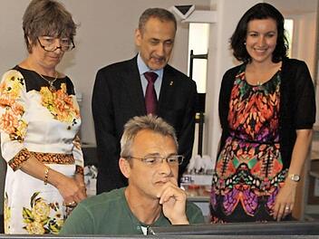 Firmenchefin Eva Maria Roer (links), Botschafter Ossama bin Abdul Majed Shobokshi und die Abgeordnete Dorothee Bär schauen Norbert Werner über die Schulter.  Foto: Edgar Bartl