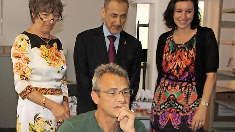 Firmenchefin Eva Maria Roer (links), Botschafter Ossama bin Abdul Majed Shobokshi und die Abgeordnete Dorothee Bär schauen Norbert Werner über die Schulter.  Foto: Edgar Bartl