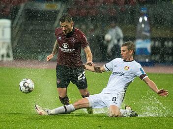 Das Hinspiel war eine richtige Wasserschlacht. In dieser Szene kämpfen Nürnbergs Tim Leibold (links) und Lars Bender um den Ball. Die Partie am 13. Spieltag endete 1:1. Foto: Nicolas Armer/dpa