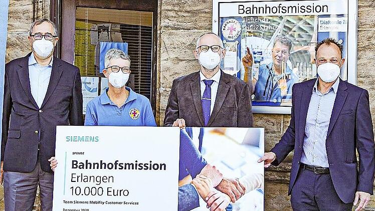 In der Bahnhofsmission in Erlangen ist die Spende von Siemens Mobility sehr willkommen; das Bild zeigt von links Peter Dunker von Siemens Mobility GmbH, Claudia Steubing, Einrichtungsleitung Bahnhofsmission Erlangen, Matthias Ewelt, Vorstand Diakonie, und Torsten Wehrkamp von Siemens Mobility GmbH.
