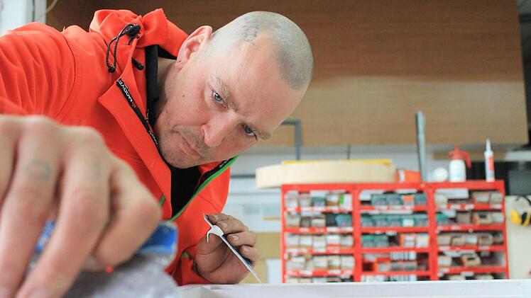 Sascha Cebeci spachtelt bei seinem neuen Arbeitgeber einen Fensterrahmen. Foto: Dominic Buckreus
