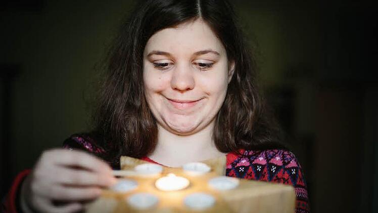Iris Zinkand zeigt einen Holzstern, in dem Trauernde je eine Kerze als symbolisches Licht für die verschiedenen Lieben entzünden.  Foto: Hendrik Steffens