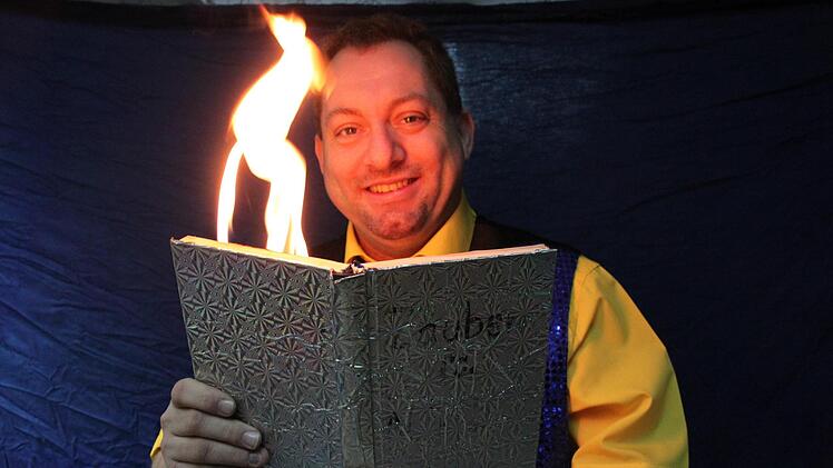 Markus Sperber schlägt ein Zauberbuch auf, murmelt kurz einen magischen Spruch und schon brennt das Buch.  Foto: Stephan Stöckel