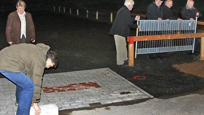 Der Verkehrsreferent macht den Weg frei: Harald Pascher hob die Sperrung des neuen Parkplatzes sprichwörtlich auf, während die Kollegen das Gitter schon auf Seite räumen.