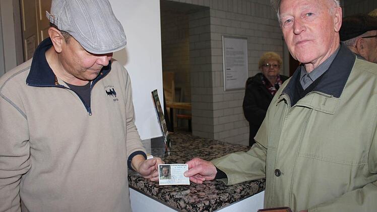Heinz Barnickel zeigt seinen Dienstausweis am Museumseingang.