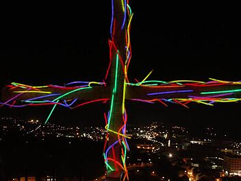 JAm Ende des Weg auf dem Burgberg umwickelten die Teilnehmer das Kreuz mit bunten Knicklichtern und stellten es unterhalb der Burg auf. Von dort strahlte es als lZeichen des Glaubens über Kulmbach. Foto: Sonja Adam