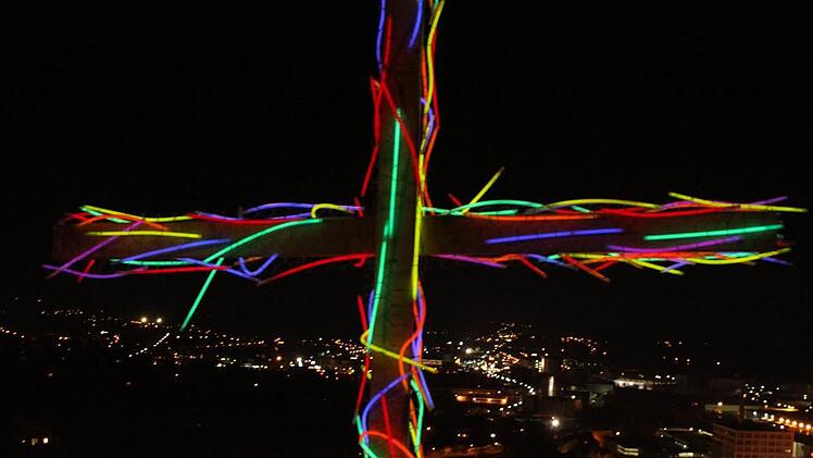 JAm Ende des Weg auf dem Burgberg umwickelten die Teilnehmer das Kreuz mit bunten Knicklichtern und stellten es unterhalb der Burg auf. Von dort strahlte es als lZeichen des Glaubens über Kulmbach. Foto: Sonja Adam
