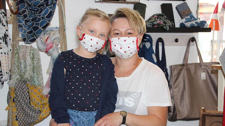 Auch das ist m&ouml;glich: Yvonne Kraus und ihre Tochter Mia tragen handgen&auml;hte Masken im Partnerlook zum Einkauf. Rote Marienk&auml;fer zieren den Stoff vor Mund und Nase. Foto: Mirjam Stumpf