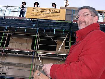 Der Landrat als Steuermann:  Michael Busch hatte die Ehre, die Richtkrone   höchstpersönlich  per  Kran und Fernsteuerung auf das Dach der neuen Straßenmeisterei zu hieven. Foto: Berthold Köhler