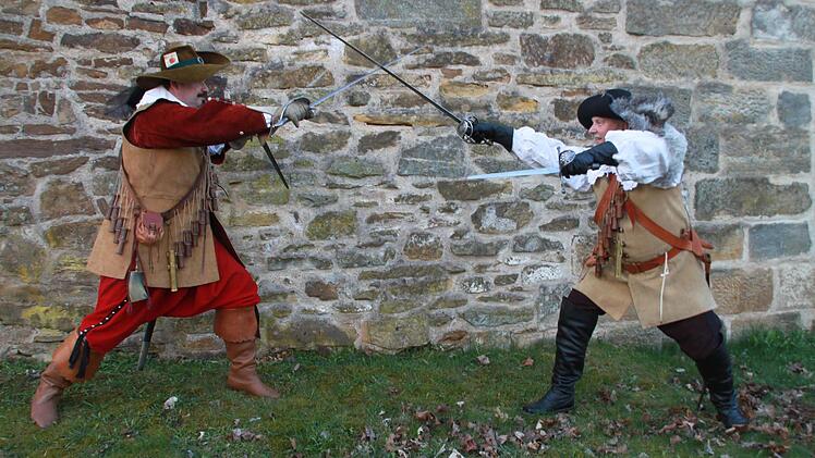 Vor der Staffelsteiner Stadtmauer stellen Christian Schunke und Edwin Rottenbach einen Kampf mit blanken Waffen nach.